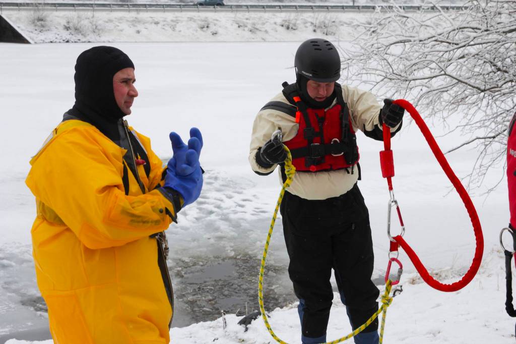 Capt. Jayme Johns, in yellow, head of the Capital City Fire/Rescues water rescue team, and Brady Fink, one of the trainers, get kitted up during CCFRs annual ice rescue training at Twin Lakes on April 7, 2021. (Michael S. Lockett / Juneau Empire)