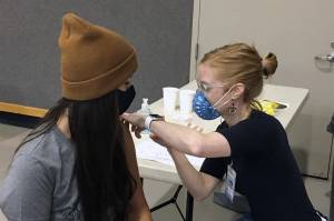Courtesy Photo / Kristin Bartlett Juneau School District
Charlee Gribbon, infection preventionist at Bartlett Regional Hospital, vaccinates Juneau School District staff member Megan Freas. Freas was one of 86 people to get vaccinated on Friday as Juneau Public Schools hosted onsite vaccine clinics at Thunder Mountain High School and Juneau-Douglas Yadaa.at Kalé High School. Students age 16 and older and staff members were eligible to be vaccinated at the clinic.