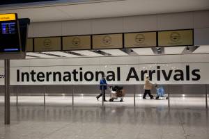 Arriving passengers walk past a sign in the arrivals area at Heathrow Airport in London, during Englands third national lockdown since the coronavirus outbreak began. On Tuesday, City and Borough of Juneau officials said the city has confirmed the first local case of a COVID-19 variant first detected in Britain. (AP Photo/Matt Dunham)
