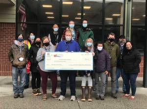 Courtesy photo / Imagine Learning 
Educators at Dzantiki Heeni Middle School hold a giant check for the food donated to the Southeast Alaska Food Bank through a drive that math students at the school participated in.