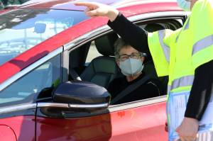 Kristi Peel checks in her electric vehicle with a volunteer ahead of a road rally held Saturday in Juneau for Earth Day. Previously, Peel said she was the proud owner of the first Chrysler PT Cruise in town. However, after about two decades and 80,000 miles, she purchased her late model Chevrolet Bolt.  (Ben Hohenstatt / Juneau Empire)