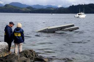 In this photo provided by the National Transportation Safety Board, NTSB investigator Clint Crookshanks, left, and member Jennifer Homendy stand near the site of some of the wreckage of the DHC-2 Beaver, Wednesday, May 15, 2019, that was involved in a midair collision near Ketchikan, Alaska, a couple of days earlier. The pilots of two Alaskan sightseeing planes that collided in midair couldnt see the other aircraft because airplane structures or a passenger blocked their views, and they didnt get electronic alerts about close aircraft because safety systems werent working properly. Thats what the staff of the National Transportation Safety board found in their investigation. (Peter Knudson / NTSB)