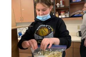 A student in Hoonah celebrates Herring Week by taking a close look at herring eggs. (Courtesy Photo / Mark Browning)