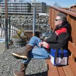 Gov. Mike Dunleavy sits beside a case containing COVID-19 vaccine doses as he waits near a floatplane dock on Thursday, April 22, 2021, in Ketchikan, Alaska. State health officials have said Alaska has an ample supply of COVID-19 vaccines, and Dunleavy, who flew from Ketchikan to Hyder, Alaska, said he wanted to offer vaccines not only to residents of Hyder but also to Canadians across the border from Hyder in Stewart, British Columbia. (AP Photo/Becky Bohrer)