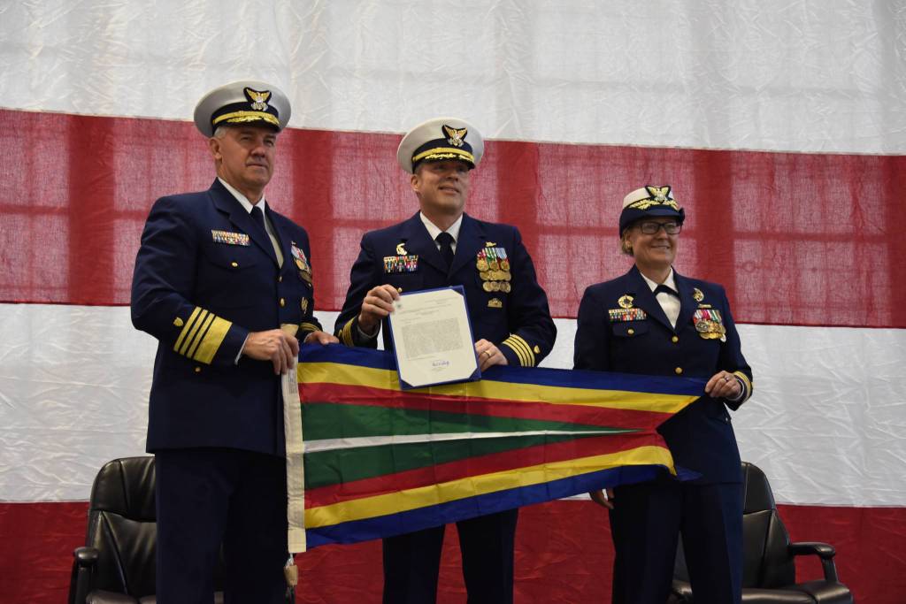 Coast Guard Commandant Adm. Karl L. Schultz, Vice Adm. Linda Fagan, and Capt. Riley Gatewood, the ships commanding officer, hold a pennant during the Coast Guard Cutter Douglas Munro decommissioning ceremony in Kodiak, Alaska, on April 24, 2021. (Petty Officer 3rd Class Janessa Warschkow / U.S. Coast Guard)