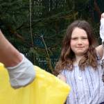 Nora Baldwin, 8, a member of Girl Scout Troop 4009, carries a dirty shirt found on the side of Mendenhall Loop Road in between gloved fingers toward a litter bag on Saturday, May 1, 2021. (Ben Hohenstatt / Juneau Empire)