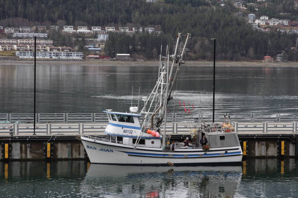 The crew of the fishing vessel San Juan release a memorial wreath into the Gastineau Channel during the 31st annual Blessing of the Fleet and Reading of Names at the Alaska Commercial Fishermens Memorial in Juneau on May 1, 2021. (Michael S. Lockett / Juneau Empire)