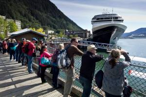 Tourists view Juneaus downtown harbor in August 2015. (Michael Penn / Juneau Empire File)