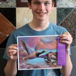 Alain Soltys-Gray holds up the award-winning piece Ducks at Dusk and a purple ribbon at Thunder Mountain High School. (Ben Hohenstatt / Juneau Empire)