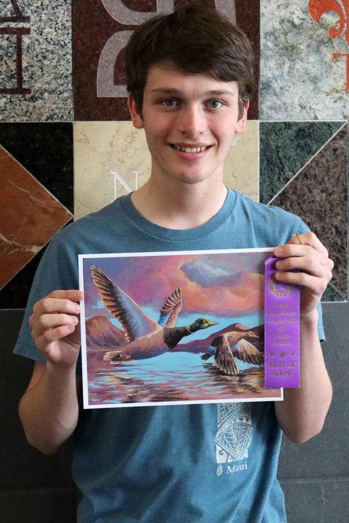 Alain Soltys-Gray holds up the award-winning piece Ducks at Dusk and a purple ribbon at Thunder Mountain High School. (Ben Hohenstatt / Juneau Empire)