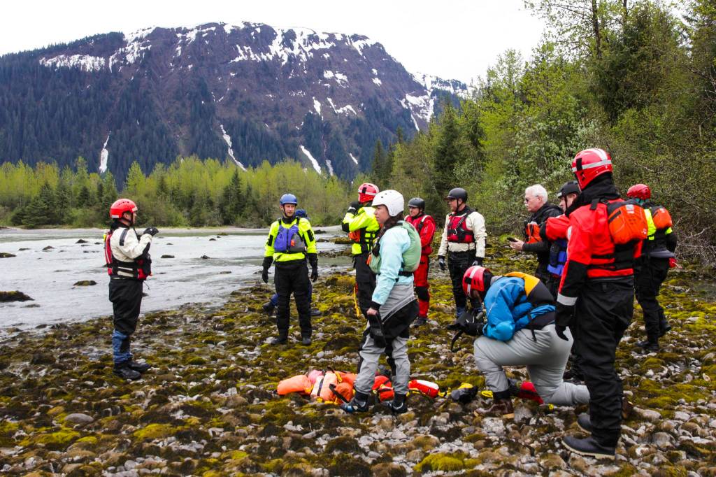 Capt. Jayme Johns, left, head of the Capital City Fire/Rescues water rescue team, briefs a group of CCFR personnel and Coast Guardsmen as they prepare to practice swiftwater rescues in the Mendenhall River on as National Boating Safety Week wraps up May 27, 2021. (Michael S. Lockett / Juneau Empire)