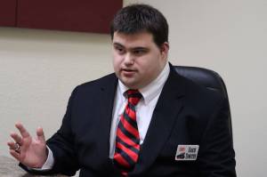David Timothy dons a state championship ring he won as a student manager with the Juneau-Douglas High School: Yadaa. at Kalé basketball team and a recently acquired coach name tag. Timothy, who has Down syndrome, was recently named an assistant basketball coach at JDHS after he passed a coaching certification exam administered by the National Federation of High Schools. (Ben Hohenstatt / Juneau Empire)