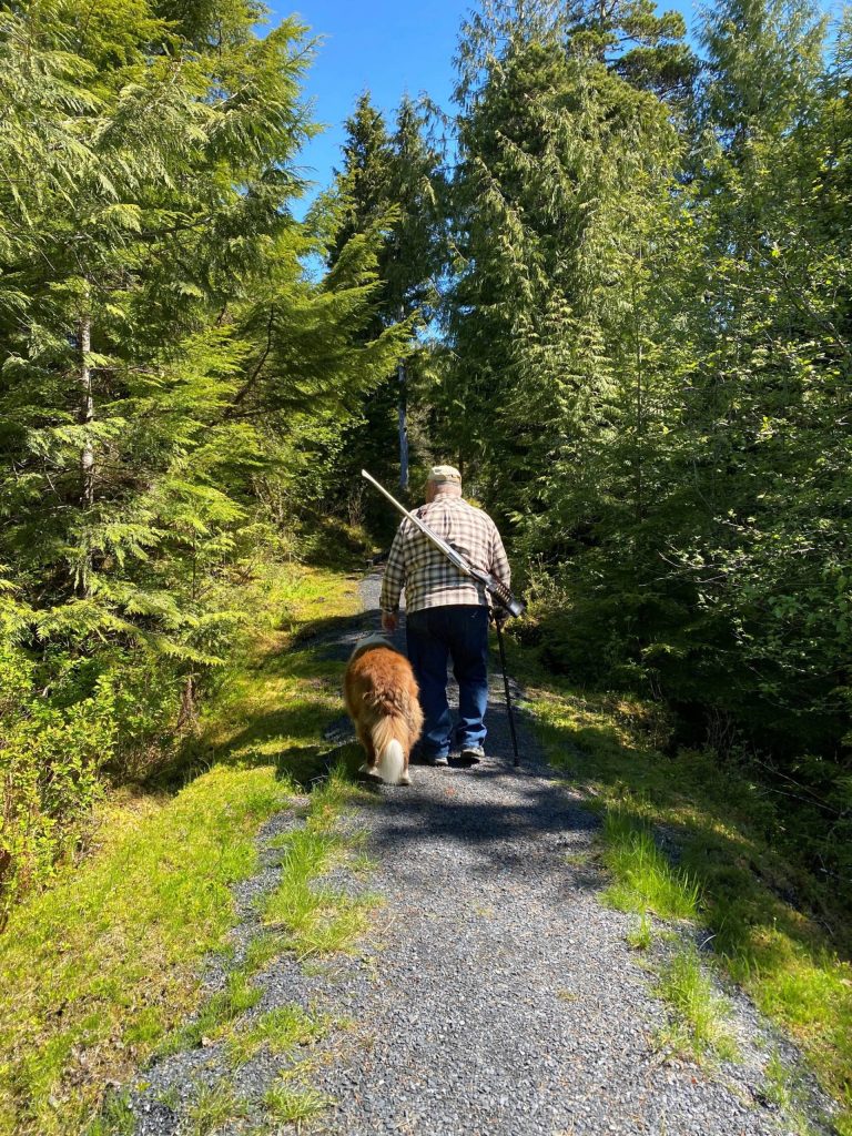 Mitchell Mickey Prescott and Oscar walk down a forest path in Wrangell. (Vivian Faith Prescott / For the Capital City Weekly)