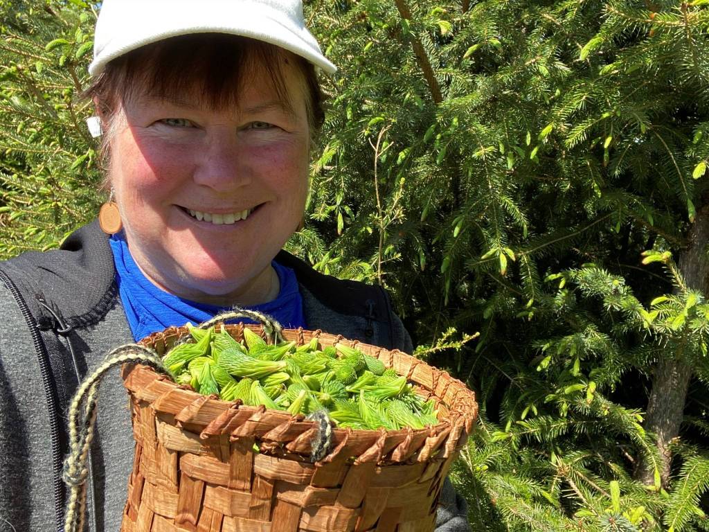 Vivian Faith Prescott, author, takes a selfie with spruce tips and cedar berry bucket woven by Faye Khort, Wrangell. (Vivian Faith Prescott / For the Capital City Weekly)
