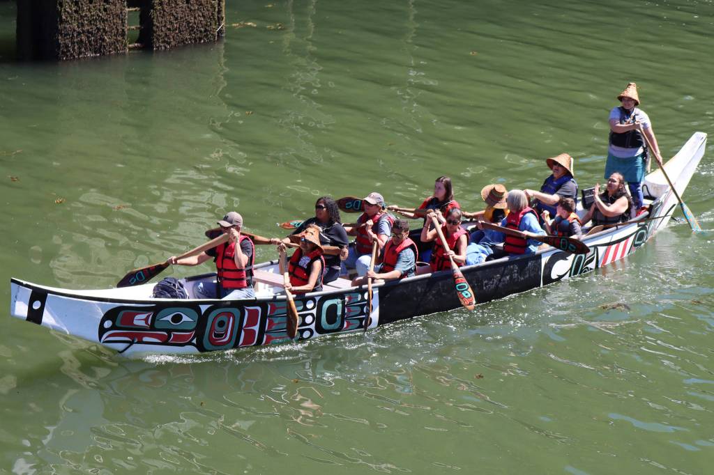 The One People Canoe Society and passengers make their way to Harris Harbor on Saturday during the Juneau Maritime Festival. (Ben Hohenstatt / Juneau Empire)