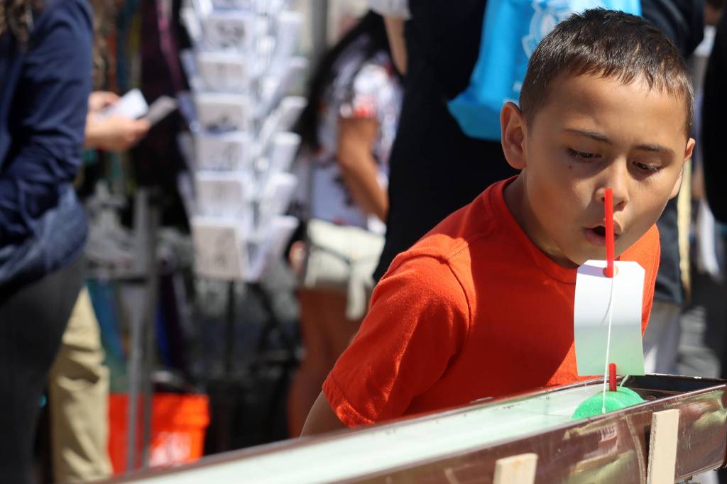 Mason John, 8, huffs and puss his noodle boat toward the finish line at the 11th Juneau Maritime Festival. For his efforts, John was awarded pirate gold that could be exchanged for a prize. (Ben Hohenstatt / Juneau Empire)