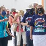 Orchid Klaric, left, assists Brenda and Kurt Duncan of Denver, with checking into their cruise, Saturday, June 26, 2021, in Fort Lauderdale, Fla. Celebrity Edge is the first cruise ship to leave a U.S. port since the coronavirus pandemic brought the industry to a 15-month standstill. The seven-night cruise will have 40 percent capacity and with virtually all passengers vaccinated against COVID-19. (AP Photo/Marta Lavandier)