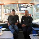 Alex Borton, left, and his father David Borton relax in the Wayward Sun, a solar-powered vessel designed by their company, Solar Sal Boats. The pair stopped in Juneau Sunday, June 27 as part of their quest to traverse Alaskas Inside Passage in a solar-powered vessel. (Dana Zigmund/Juneau Empire)
