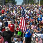 People follow the One Peoples Canoe Society canoe to Savikko Park at the end of the Douglas Fourth of July Parade on Thursday, July 4, 2019. After the pandemic forced a hiatus on festivities last year, a full slate of activities are scheduled for this weekend. (Michael Penn/Juneau Empire File)