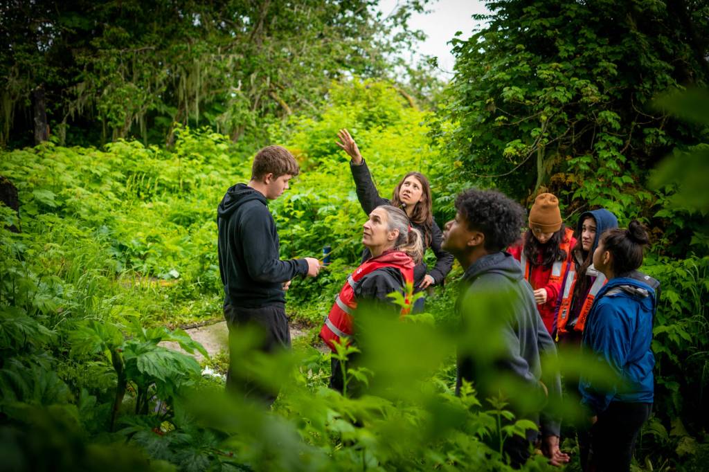 Photo by Lione Clare 
The Kake Alaska Youth Stewards crew plans out where a set of stairs will be placed to improve the user trail on Grave Island, where many sites are overgrown and difficult to access, especially for elders.