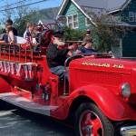 An antique fire truck makes its way along the Douglas parade route on Sunday, July 4, 2021. (Dana Zigmund / Juneau Empire)