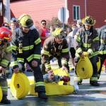 Members of Capital City Fire and Rescue competed in the “Olde Time Fireman’s Hose Race” as hundreds cheered the different crews in their efforts to quickly unroll and connect the hose to water in front of the Volunteer Fire House. (Dana Zigmund/Juneau Empire)