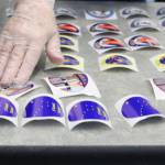 An election official lays out more "I voted" stickers on Tuesday, Nov. 3. Stickers for the 2020 general election featured designs by Alaskan artist Barbara Lavallee. Election officials in Juneau said the sticker depicting a pair of Neoprene boots ha been particularly popular. (Ben Hohenstatt / Juneau Empire)
