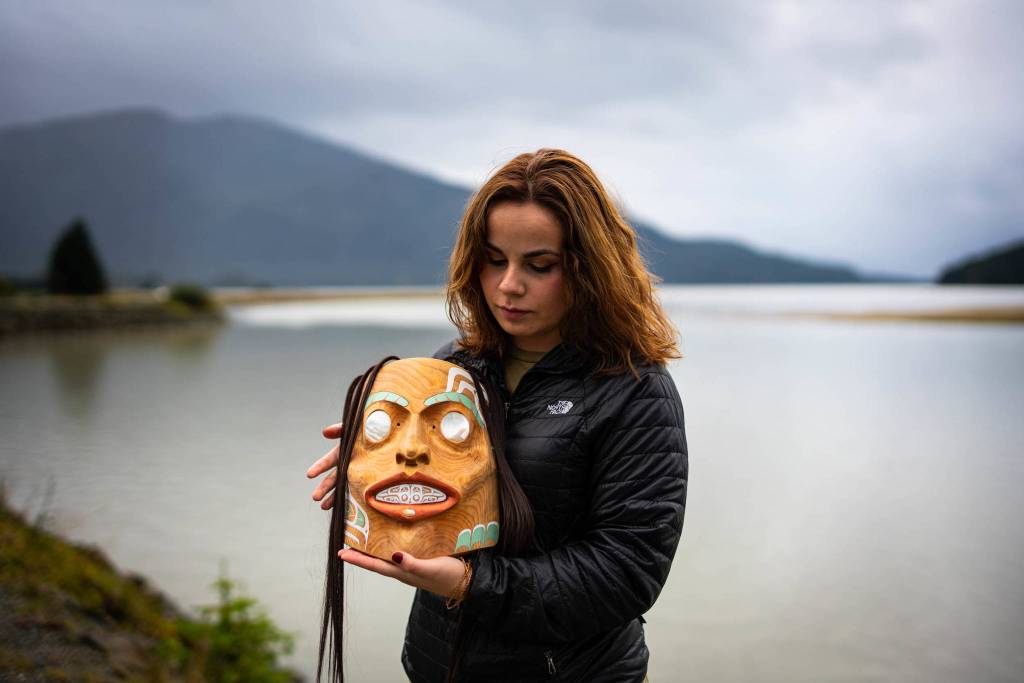 In 2020, Sienna Reid of Sitka and Andrea Cook, Tsaak Ka Juu of Hydaburg, pictured here holding her first carved mask, worked with the First Alaskans Institute, Sitka Conservation Society, the Pacific Northwest Research Lab and SSP to document the social, economic, and cultural value of red and yellow cedar to Alaska Native artisans and communities. (Courtesy Photo / Bethany Sonsini Goodrich)