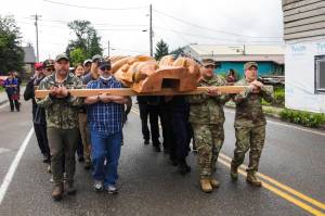 Veterans and active duty servicemembers carry the totem pole on July 24, 2021 as hundreds gathered in Hoonah for its raising. (Michael S. Lockett / Juneau Empire)