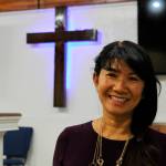 In this May 24, 2021, photo, Linda Dunegan poses for a photo in the sanctuary of the Open Door Baptist Church in Anchorage, Alaska. Dunegan purchased a former strip club and leased the main floor to the church. (AP Photo/ Mark Thiessen)