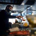 In this April 6 photo, bartender Denis Angelov pours drinks at Tin Pan Alley restaurant in Provincetown, Mass. A study of a large coronavirus outbreak in Provincetown suggests the amount of virus in fully vaccinated people was as great as the viral load in unvaccinated people. Health officials released the study Friday, July 30, 2021, saying it explains their call this week for vaccinated people return to wearing masks indoors in parts of the U.S. where the delta variant of the coronavirus is fueling infection surges. The study focused on an outbreak this month in Provincetown, a seaside tourist spot located in the Massachusetts county with the state's highest vaccination rate. (AP Photo/Steven Senne)