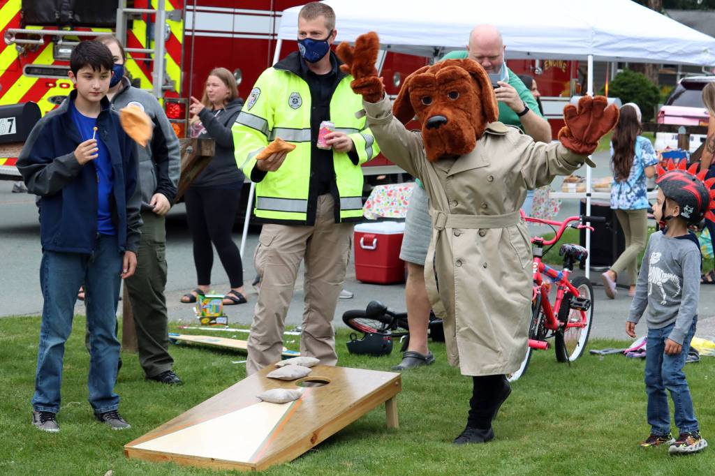 McGruff the Crime Dog lets a bag fly during National Night Out. Police officers, emergency medical responders, firefighters, search and rescue personnel partiicipated in the annual event that gets first responders involved in their communities across the neation. (Ben Hohenstatt / Juneau Empire)