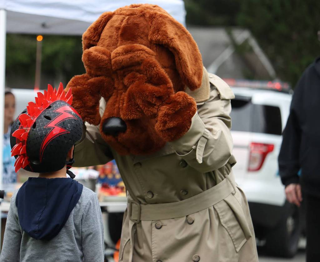 James Lemons, 5, talks to McGruff the Crime Dog after a game of cornhole during National Night Out. Earlier in the event, Lemons asked if he could pet McGruff, which led to a queue of children petting the Crime Dogs head. (Ben Hohenstatt / Juneau Empire)