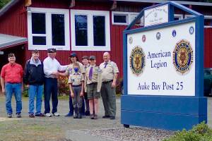 Eagle Scout Kristofer Ely and American Legion Post Commander Tom Dawson shake hands at the unveiling of the new sign outside Auke Bay Post 25. Ely executed a project replacing the old sign with the new one. (Courtesy photo / Tom Dawson)