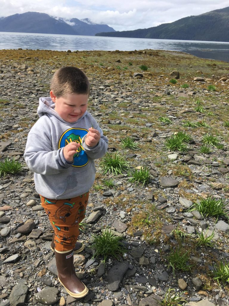 Jonah Hurst learns to identify arrowgrass and goose tongue in Wrangell. (Vivian Faith Prescott / For the Capital City Weekly)