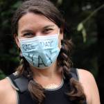 Juneau resident Katie Kowalchuk let her mask express her excitement before competing in the Aukeman Triathlon on Saturday, August 7. Organizers adopted COVID mitigations, including pre-race masking and distancing, as part of the event. (Dana Zigmund/Juneau Empire)