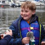 Nathan Olson, 10, smiles after winning $200 from a punchboard set up at the Auke Bay Harbor weigh station Saturday during the 75th annual Golden North Salmon Derby. The board was the brainchild of Venietia Bingham, owner of Vs Cellar Door. It featured prizes from the restaurant as well as Jewels by Kris. (Ben Hohenstatt / Juneau Empire)