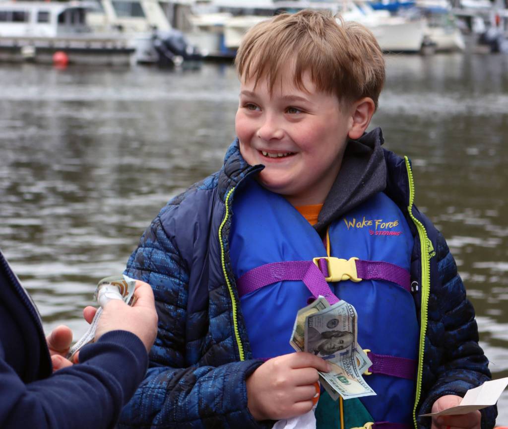 Nathan Olson, 10, smiles after winning $200 from a punchboard set up at the Auke Bay Harbor weigh station Saturday during the 75th annual Golden North Salmon Derby. The board was the brainchild of Venietia Bingham, owner of Vs Cellar Door. It featured prizes from the restaurant as well as Jewels by Kris. (Ben Hohenstatt / Juneau Empire)
