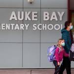 Kalei Shotwell walks third grade student Loche Hanselman and first grade student Ady Hanselman into Auke Bay Elementary School on Monday morning. Shotwell said she was both excited and nervous about the return of in-person, five-days-a-week school. Shotwell said she is impressed with Juneau School Districts mitigation policies. I give the school a lot of credit, Shotwell said. It feels normal, and I think thats a big deal for most people. (Ben Hohenstatt/Juneau Empire)