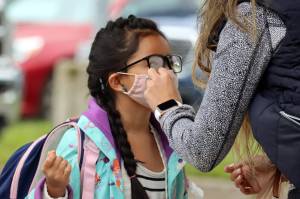 Vanessa Dickinson adjusts second grade student Kanani Dickinsons mask ahead of the first day of school. Kanani Dickinson is a student at Auke Bay Elementary School. Vanessa Dickinson said shes excited the 7-year-old is back in school. (Ben Hohenstatt / Juneau Empire)