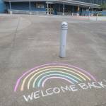 A sidewalk-based message welcomes students and staff back to Glacier Valley Elementary School ahead of the first day of school on Monday, Aug. 16. (Ben Hohenstatt/Juneau Empire)