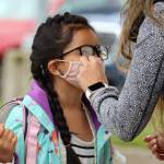 Vanessa Dickinson adjusts second grade student Kanani Dickinson's mask ahead of the first day of school. Kanani Dickinson is a student at Auke Bay Elementary School. Vanessa Dickinson said she's excited the 7 year old is back in school. (Ben Hohenstatt / Juneau Empire)