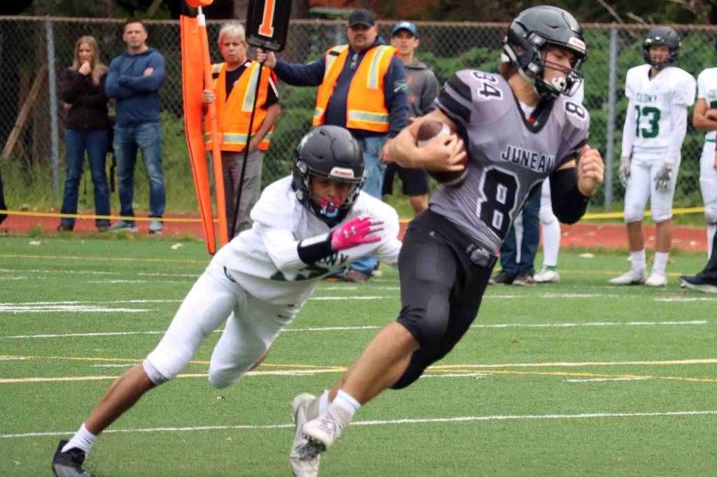 photos by Ben Hohenstatt / Juneau Empire 
Wallace Adams makes his way up field after catching a pass Saturday. In addition to his work as a receiver, Adams opened scoring for Juneau with a field goal and forced a key fumble. Right, Noah Chambers throws the ball downfield
