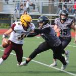 Wyatt Harvey (14) and Brandon Campbell (65) pursue Dimonds quarterback. Campbell was responsible for a key goal-line stop for Juneau in Saturdays win. (Ben Hohenstatt / Juneau Empire)