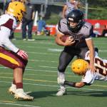 Jamal Johnson fights for extra yards during Juneau's 35-6 win against Dimond High School on Saturday, Aug. 21. (Ben Hohenstatt / Juneau Empire)