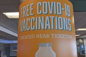 A sign advertises free COVID-19 vaccines at the Ted Stevens Anchorage International Airport on July 13, 2021, in Anchorage, Alaska. The state announced a new initiative that gives newly vaccinated Alaskans an opportunity to win $49,000. (Photo by Erin Thompson/Peninsula Clarion)
