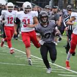 Juneaus Gaby Soto, a senior, runs down the sideline pursued by East Anchorage High School defenders. Soto intentionally ended his long, late-fourth-quarter run short of the goal line, but would subsequently rush for a touchdown. (Ben Hohenstatt / Juneau Empire)