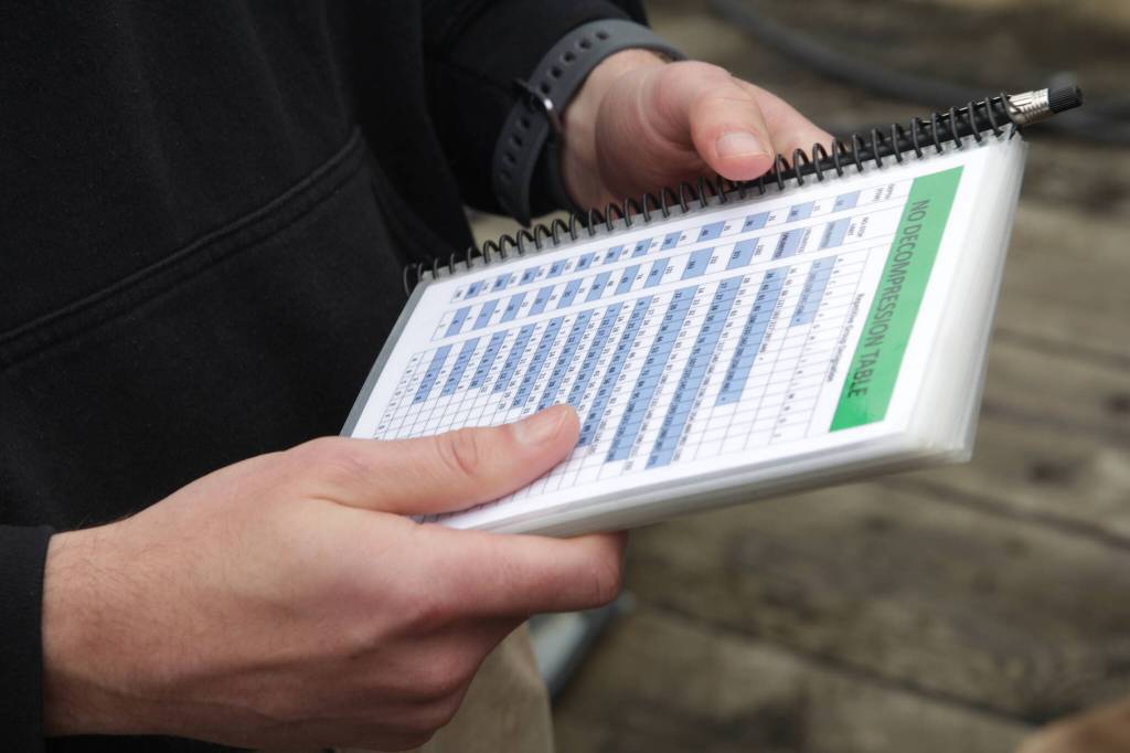 Capt. Kevin Hadden holds a dive chart during a training exercise in Juneau with a Coast Guard dive team on Sept. 6, 2021. (Courtesy photo / MyKenzie Robertson)