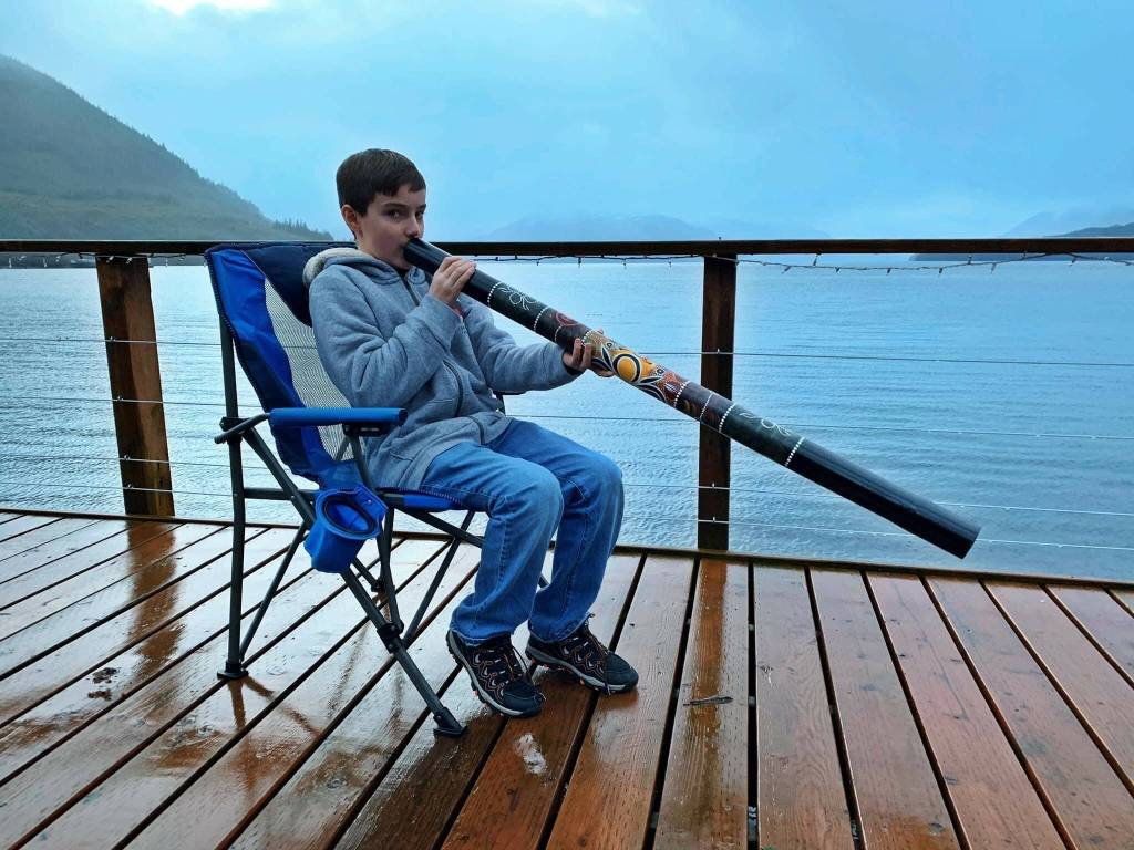 Jackson Pearson tries out a didgeridoo, Mickeys Fishcamp in Wrangell. (Vivian Faith Prescott / For the Capital City Weekly)