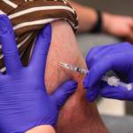 A Juneau resident receives the booster shot for the Pfizer coronavirus vaccine at Centennial Hall on Oct. 2, 2021. More than 1,300 Juneau residents received booster shots at the clinic. (Michael S. Lockett / Juneau Empire)